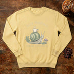 Slow Mornings Snail Sweatshirt in Butter, a sleepy snail carrying a coffee cup on its shell