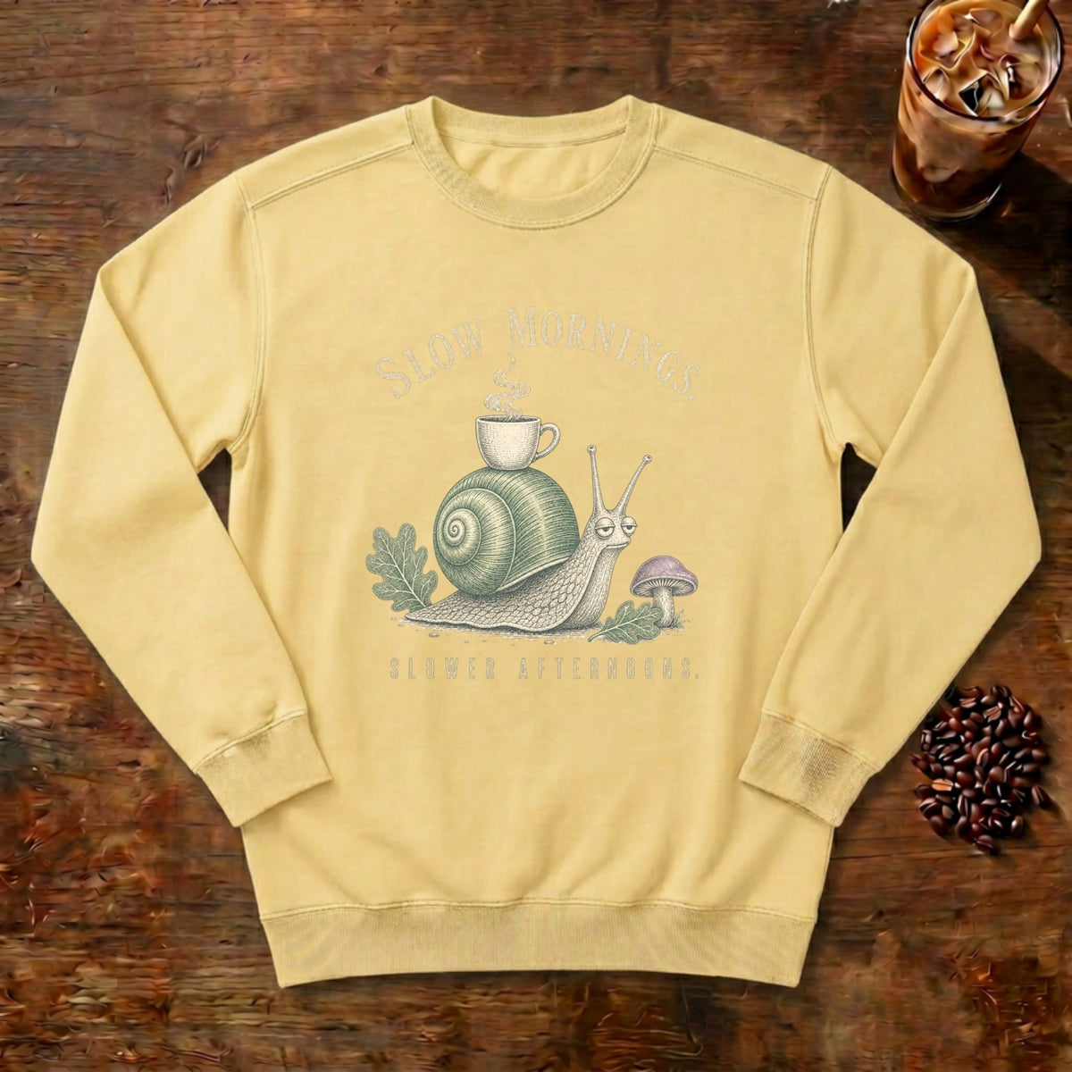 Slow Mornings Snail Sweatshirt in Butter, a sleepy snail carrying a coffee cup on its shell