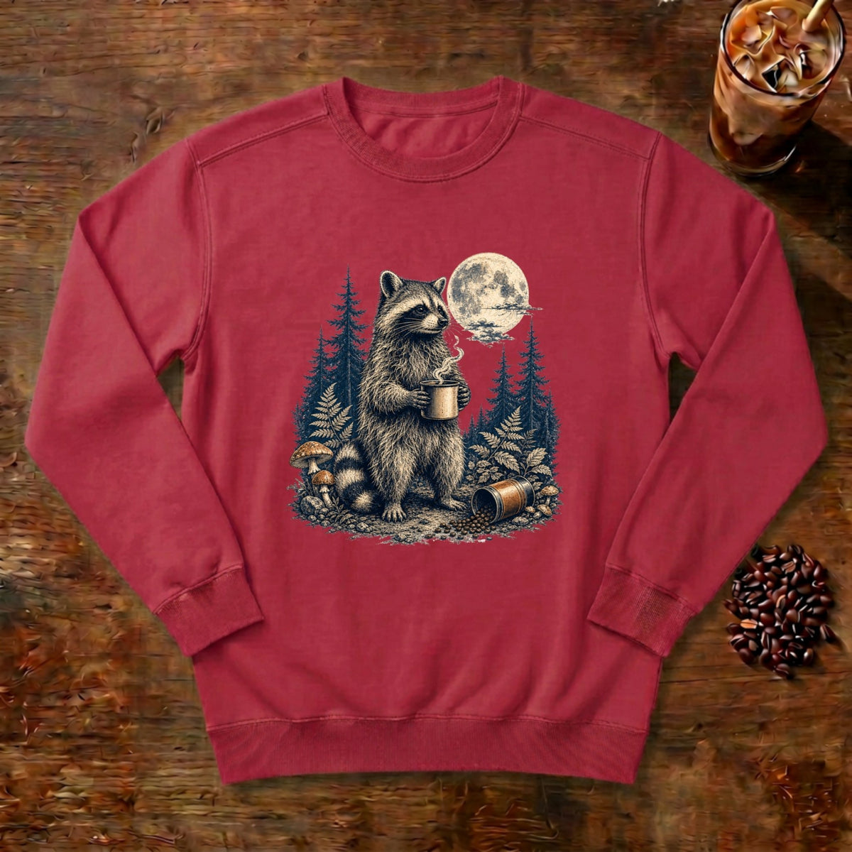 Moonlit Raccoon Coffee Sweatshirt in Crimson, a raccoon with coffee in a moonlit forest