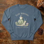 Slow Mornings Snail Sweatshirt in Denim, a sleepy snail carrying a coffee cup on its shell