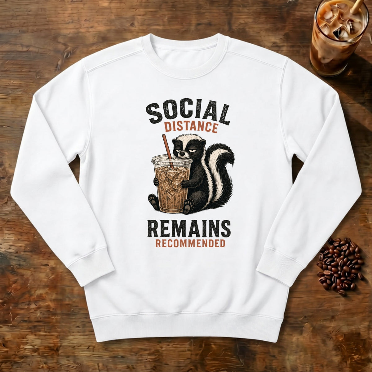 Social Distance Remains Skunk Sweatshirt in White, a retro skunk sipping iced coffee