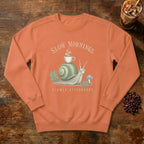 Slow Mornings Snail Sweatshirt in Terracotta, a sleepy snail carrying a coffee cup on its shell