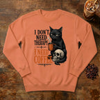 I Don't Need Therapy Cat Sweatshirt in Terracotta, a black cat holding a coffee mug and sitting on a skull