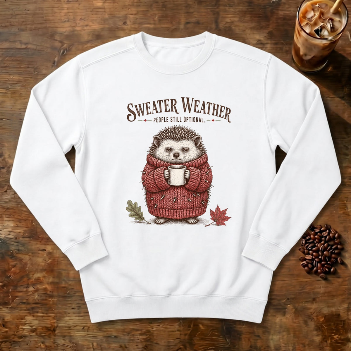 Sweater Weather Hedgehog Sweatshirt in White, a hedgehog in a knit sweater holding a mug