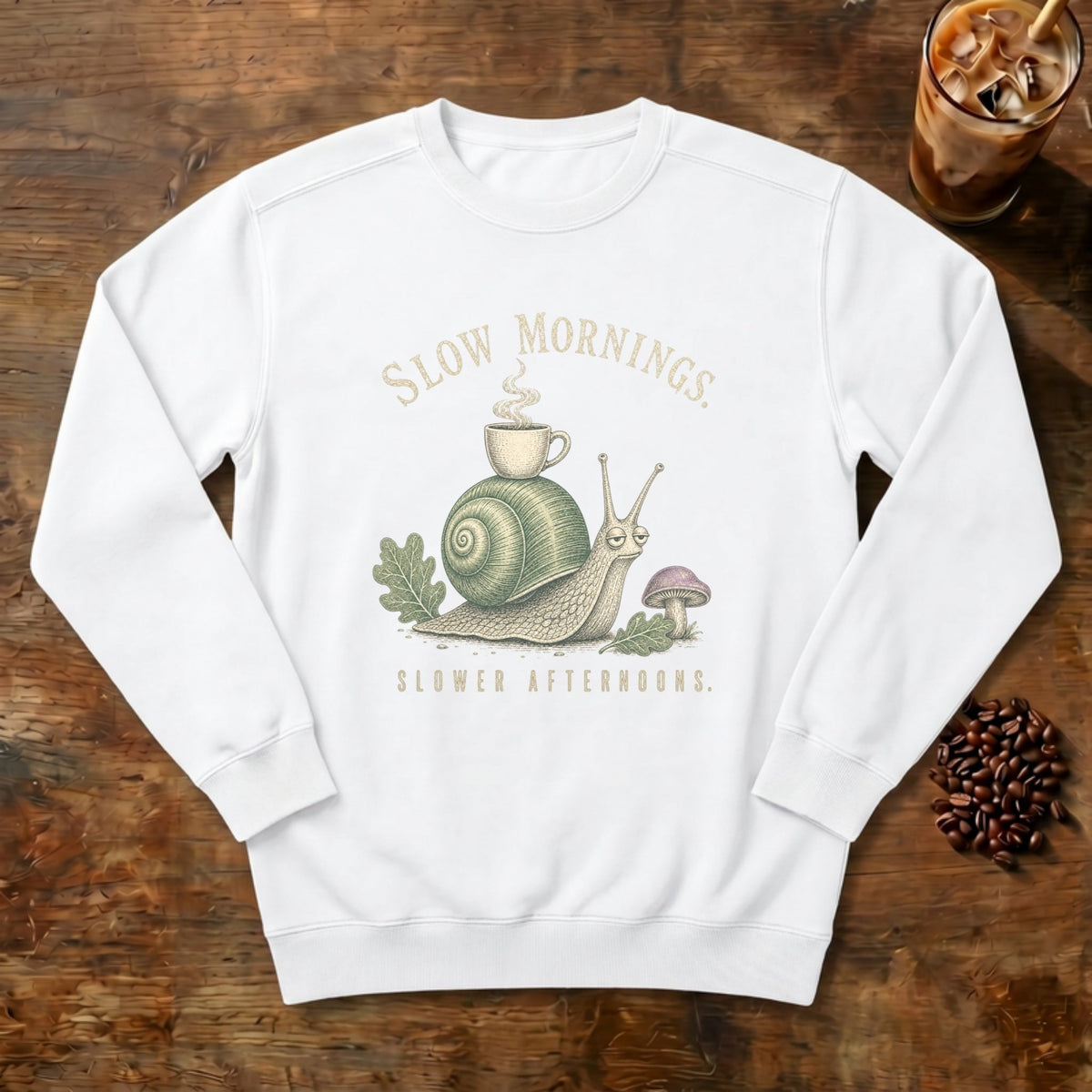 Slow Mornings Snail Sweatshirt in White, a sleepy snail carrying a coffee cup on its shell