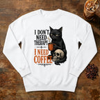 I Don't Need Therapy Cat Sweatshirt in White, a black cat holding a coffee mug and sitting on a skull