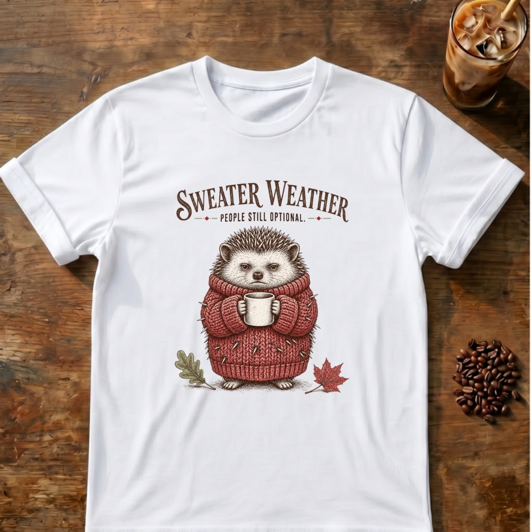 Small hedgehog in a chunky red knit sweater holding a mug with the words Sweater Weather. People Still Optional on a White T-shirt.