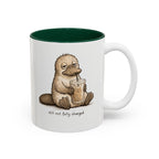 Still Not Fully Charged Platypus Coffee Mug, white with green interior. Sleepy platypus sipping iced coffee with “still not fully charged” text