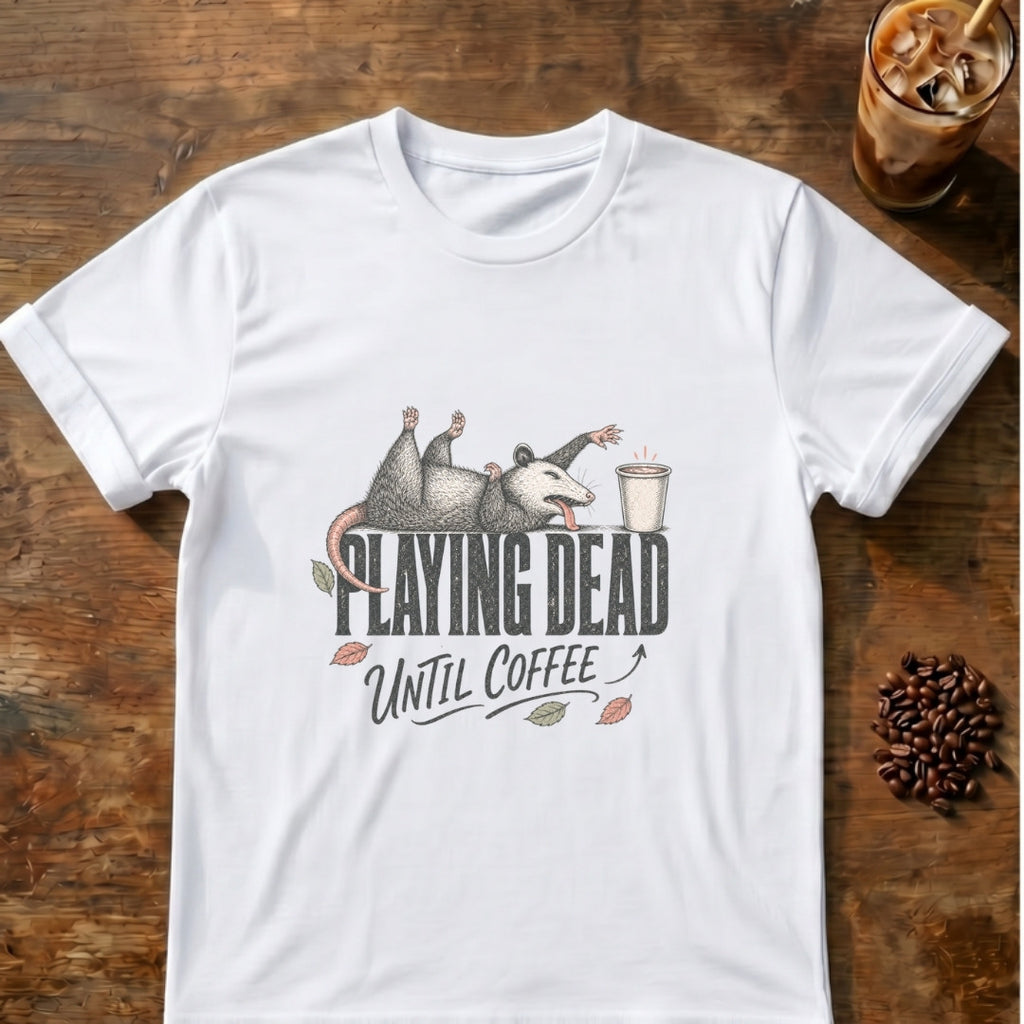 Exhausted opossum sprawled on its back playing dead on top of the words Playing Dead, reaching for a coffee cup, with Until Coffee below on a White T-shirt.
