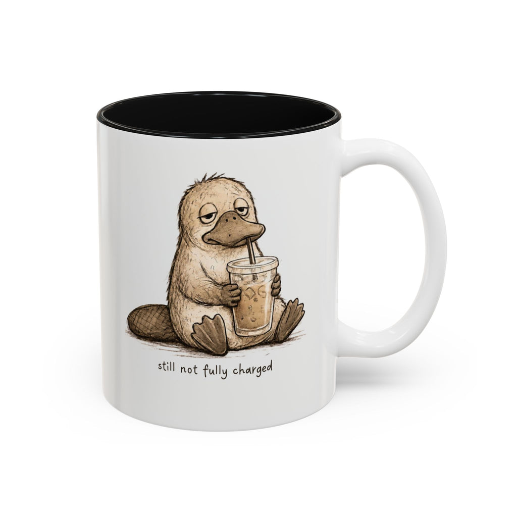Still Not Fully Charged Platypus Coffee Mug, white with black interior. Sleepy platypus sipping iced coffee with “still not fully charged” text