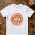 Contented raccoon lounging in a pie tin with a fork and a latte inside a round badge with the words Leftovers & Lattes on a White T-shirt.