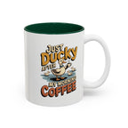 Just Ducky After My Morning Coffee Mug, another view. Cheerful duck raising a coffee cup in a pond with ducklings and “Just Ducky After My Morning Coffee” text