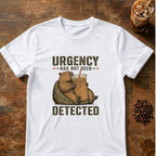 Relaxed capybara holding a giant iced coffee beneath the words Urgency Has Not Been Detected on a White T-shirt.