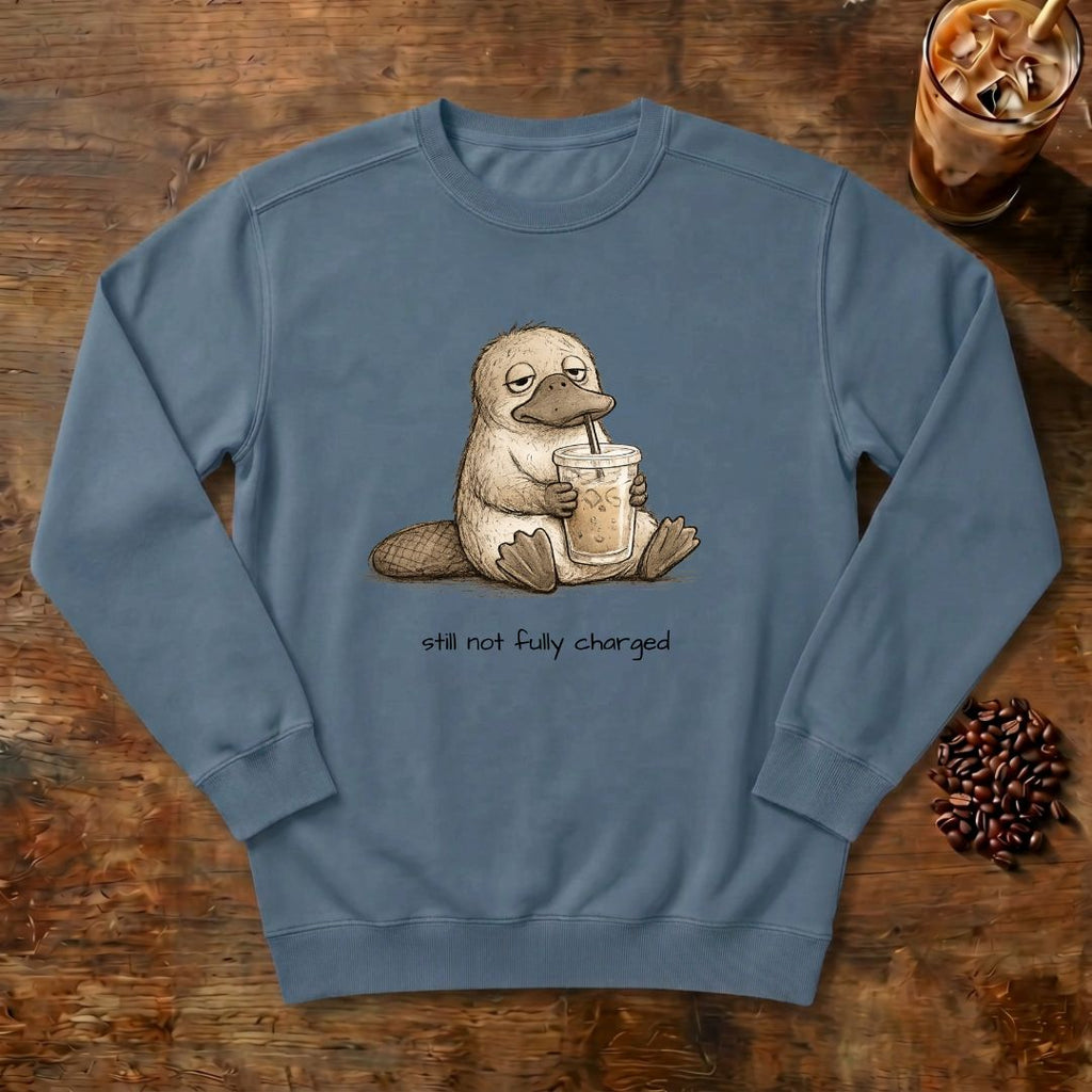 Still Not Fully Charged Platypus Sweatshirt in Denim, a sleepy platypus sipping iced coffee
