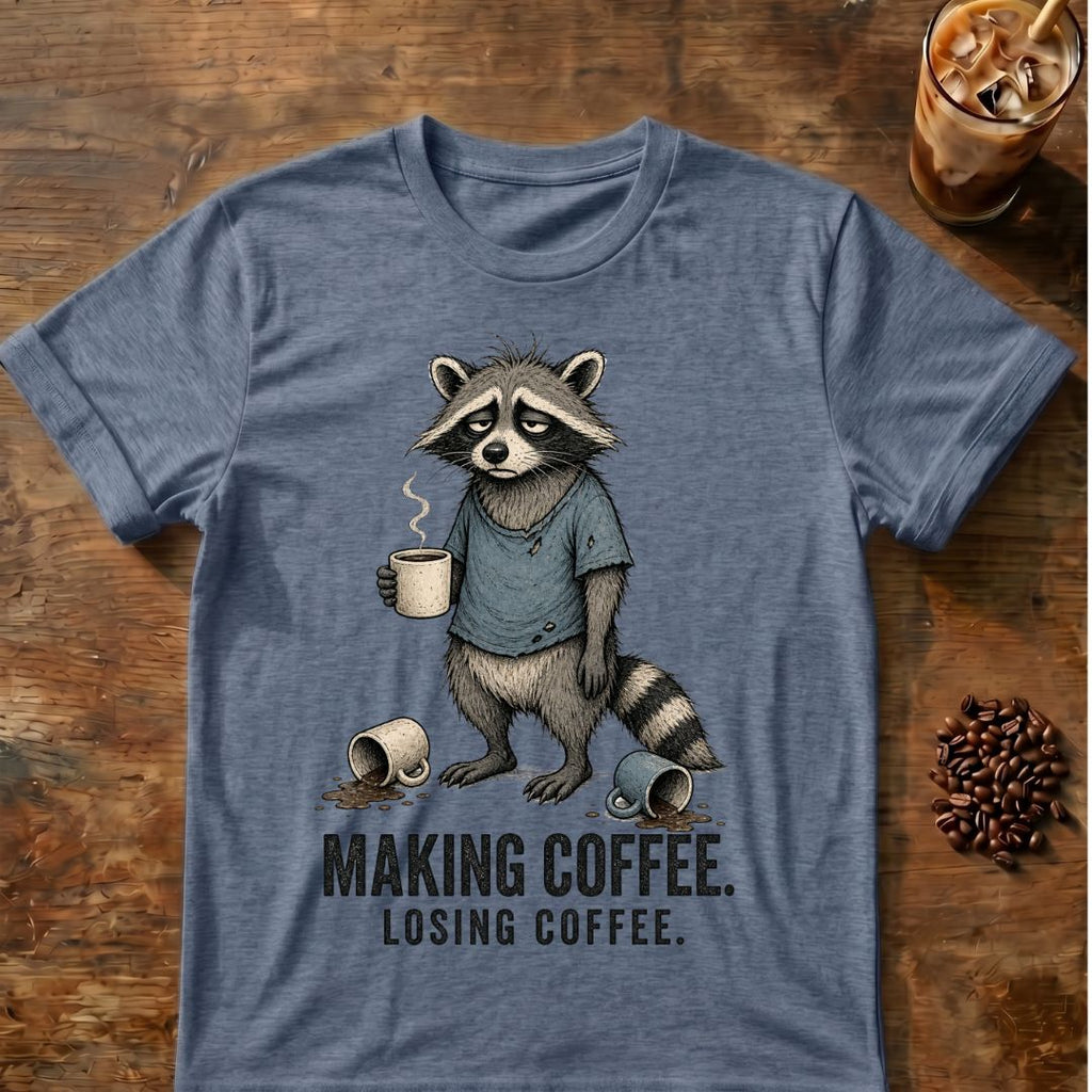 Raccoon coffee graphic on a Heather Indigo T-shirt