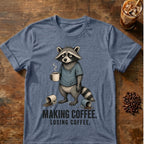 Raccoon coffee graphic on a Heather Indigo T-shirt