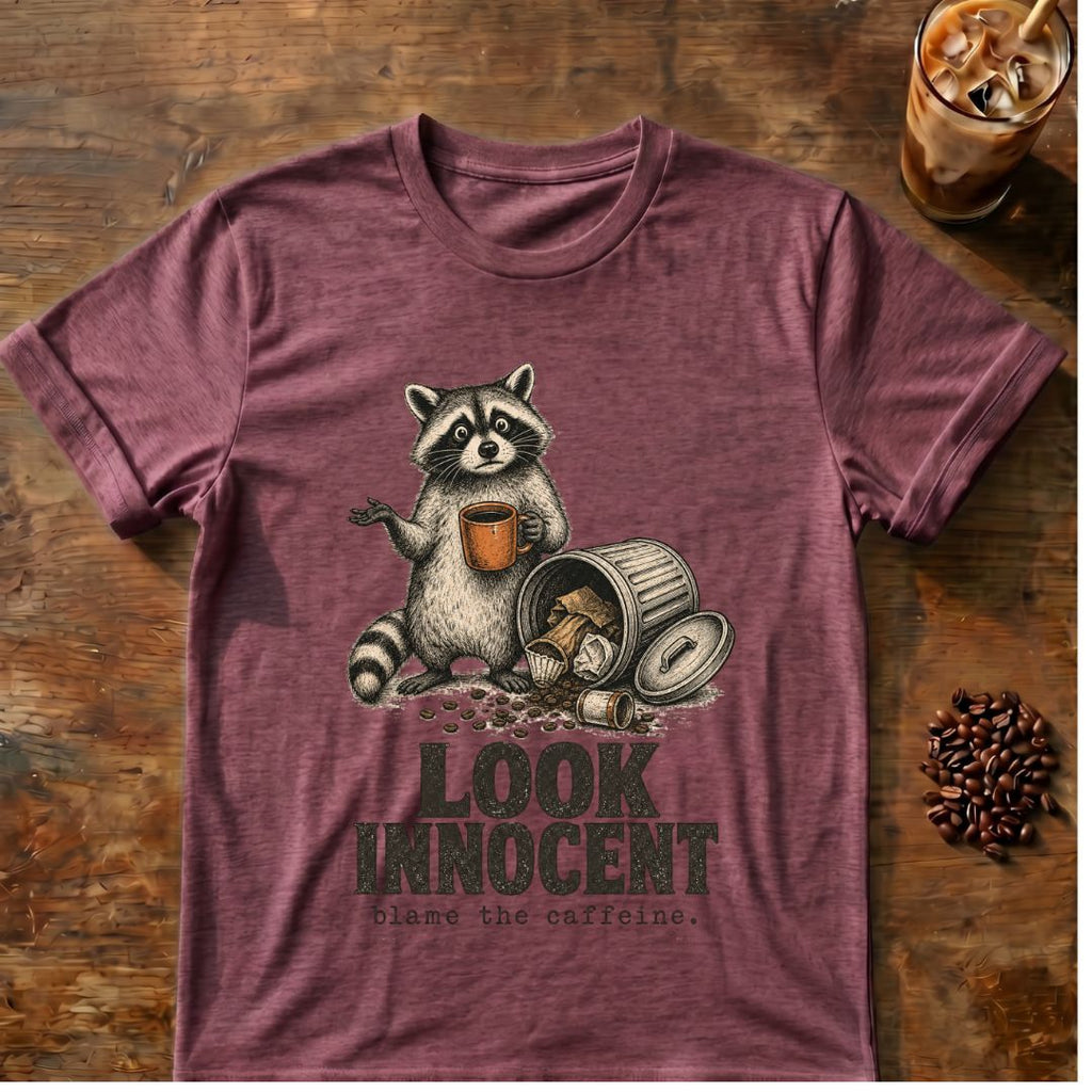 Raccoon coffee graphic for Look Innocent Raccoon on heather-maroon T-shirt
