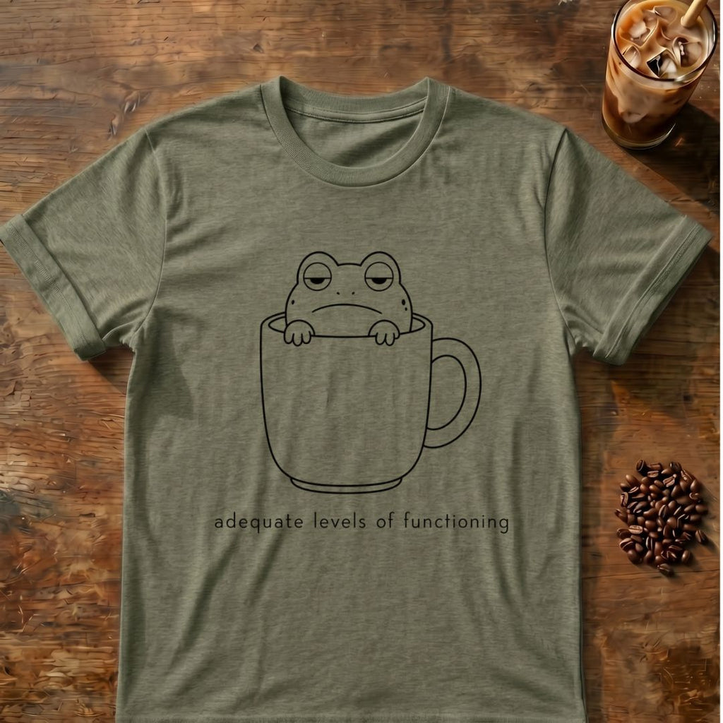 Tired frog sitting inside a coffee mug with “adequate levels of functioning” text