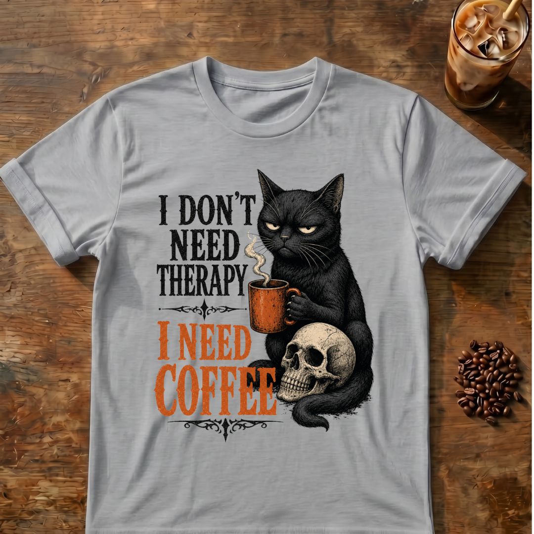 Unimpressed black cat holding an orange coffee mug beside a skull with the words I Don't Need Therapy, I Need Coffee.