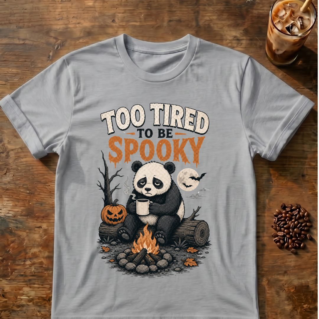 Sleepy panda holding coffee beside a campfire and jack-o'-lantern with “Too Tired to Be Spooky” text