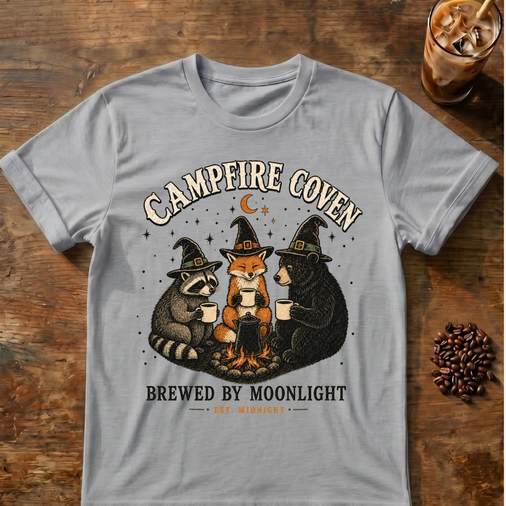 Raccoon, fox and bear in witch hats gathered around a campfire coffee pot with “Campfire Coven” text