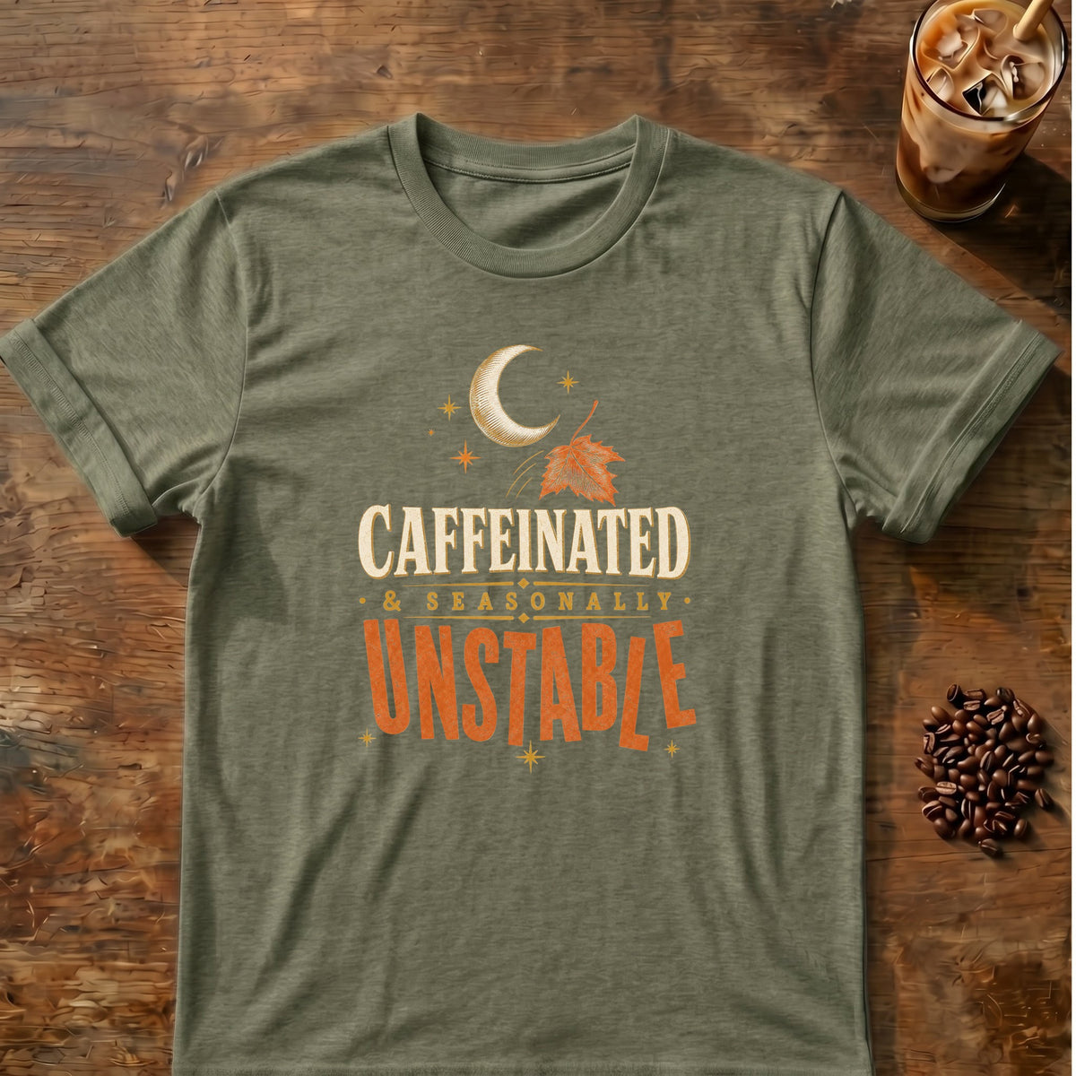 Typography graphic for Caffeinated & Seasonally Unstable on heather-military-green T-shirt